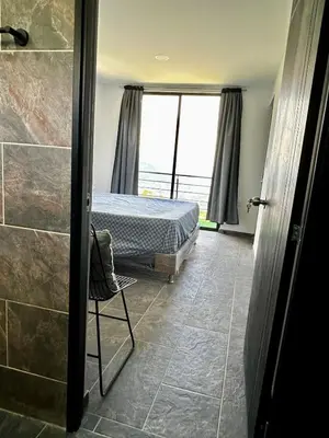 a bedroom with a bed and a shower with a window at Finca Privada San Felix, Jacuzzi, Vistas Panoramicas Medellin
