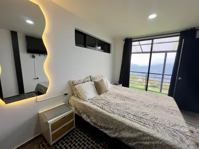 a bedroom with a bed and a large window at Finca Privada San Felix, Jacuzzi, Vistas Panoramicas Medellin