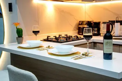 a kitchen with a stove and two glasses of wine at Apartment suite Encanto de Caldas in Ruiosucio