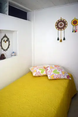 a bedroom with a yellow bed and two pillows at La 47 House - Family House in Manizales in Manizales
