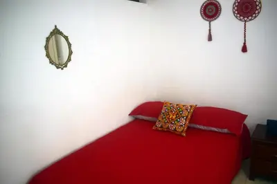 a red bed with a red pillow and a mirror at La 47 House - Family House in Manizales in Manizales
