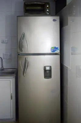 a refrigerator in a kitchen with a microwave on top of it at La 47 House - Family House in Manizales in Manizales
