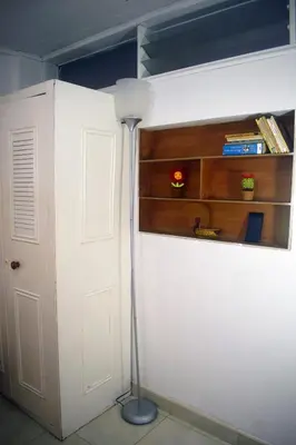a room with a white wall with a lamp next to a door at La 47 House - Family House in Manizales in Manizales