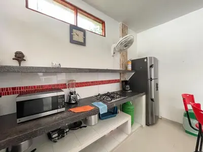 a kitchen with a stove and a refrigerator at Plaza Blanca 2 cabaña en el Santorini Colombiano in Doradal