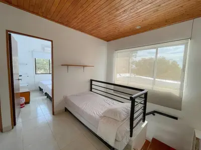 a bedroom with a bed and a large window at Plaza Blanca 2 cabaña en el Santorini Colombiano in Doradal