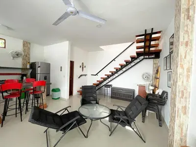 a living room with a table and chairs and a staircase at Plaza Blanca 2 cabaña en el Santorini Colombiano in Doradal