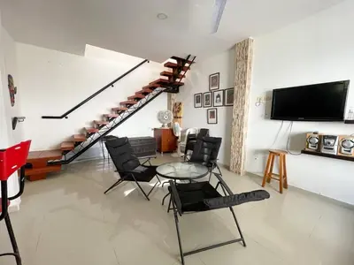 a living room with a table and chairs and a staircase at Plaza Blanca 2 cabaña en el Santorini Colombiano in Doradal