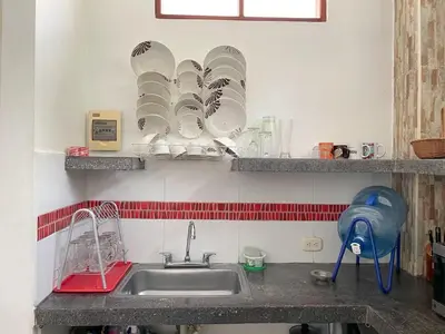 a kitchen counter with a sink and plates on the wall at Plaza Blanca 2 cabaña en el Santorini Colombiano in Doradal