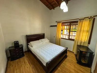 a bedroom with a bed and a table and a window at Casa Finca Villa Laura 158 in Rionegro