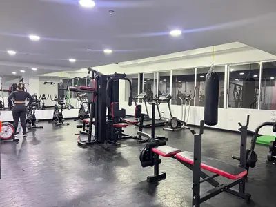 a gym with lots of machines and a man in the background at Apartamento Familiar en Sabaneta cerca al parque in Sabaneta
