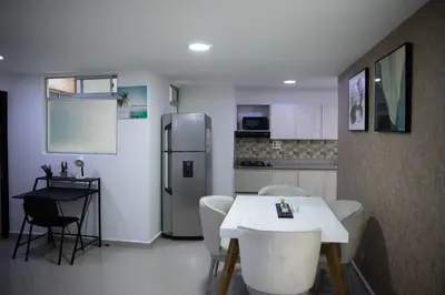 a kitchen with a table and chairs and a refrigerator at 901-Apartamento Central Parque de Sabaneta in Sabaneta