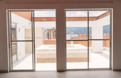 an open glass door with a view of a building at 901-Apartamento Central Parque de Sabaneta in Sabaneta