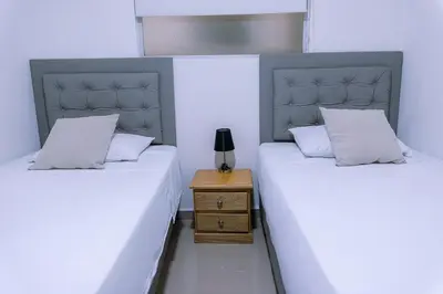 two twin beds in a room with a night stand at 901-Apartamento Central Parque de Sabaneta in Sabaneta