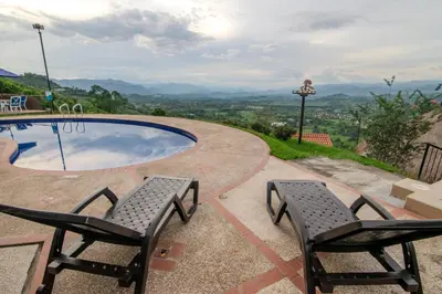 two chairs and a swimming pool with mountains in the background at Altos de Balaguer in Magallenes