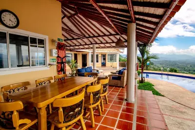 a patio with a wooden table and chairs and a pool at Altos de Balaguer in Magallenes