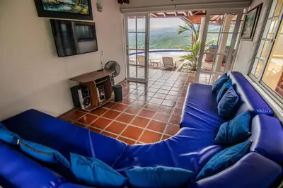 a living room with a blue couch and a balcony at Altos de Balaguer in Magallenes
