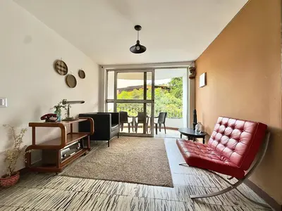 a living room with a red couch and a table at CASA JAGUAR 4 Habitaciones, 4 Baños in Medellín