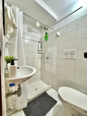 a white bathroom with a toilet and a sink at CASA JAGUAR 4 Habitaciones, 4 Baños in Medellín