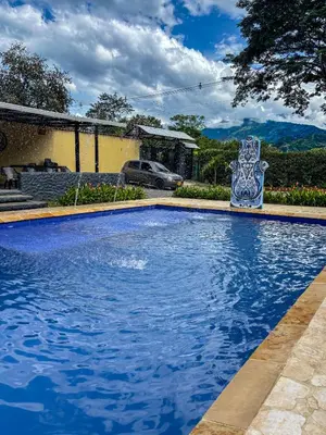 a blue swimming pool with a bench in front of a house at Villa Sol in Sopetran