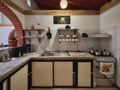 a kitchen with a sink and a stove at Casa Amaru Rooms in Guarne