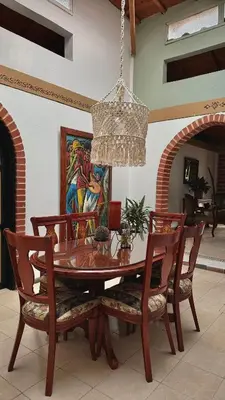 a dining room table with chairs and a chandelier at Casa Amaru Rooms in Guarne