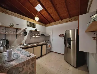 a large kitchen with a stainless steel refrigerator at Casa Amaru Rooms in Guarne