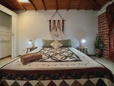 a bedroom with a large bed with two tables at Casa Amaru Rooms in Guarne