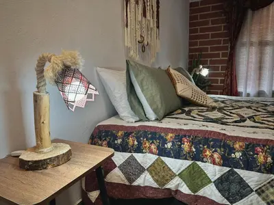 a bedroom with a bed and a table with a lamp at Casa Amaru Rooms in Guarne