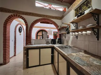 a kitchen with arches and a sink and a counter at Casa Amaru Rooms in Guarne