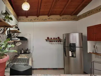 a kitchen with a stainless steel refrigerator at Casa Amaru Rooms in Guarne