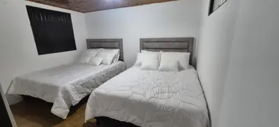 a bedroom with two beds with white sheets at Hospedaje en Marulanda in Marulanda