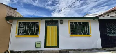 a white house with yellow doors and windows at Hospedaje en Marulanda in Marulanda
