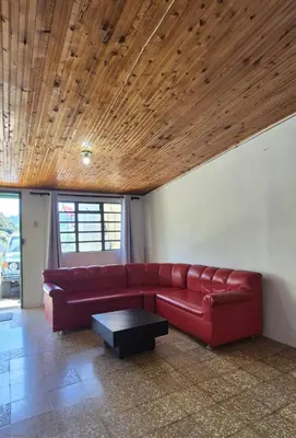 a living room with a red couch and a table at Hospedaje en Marulanda in Marulanda