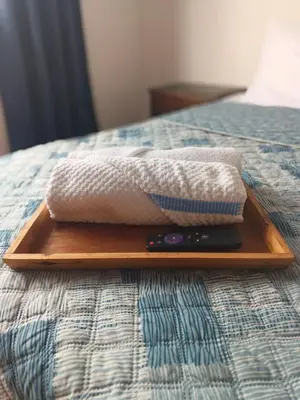 a wooden tray with a towel and a remote on a bed at La Arboleda Apartamento in Manizales