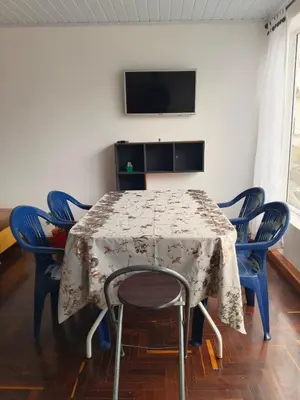 a table with chairs and a tv on a wall at La Arboleda Apartamento in Manizales