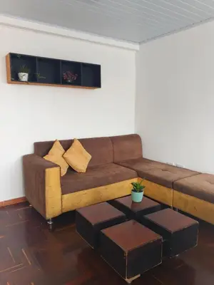 a living room with a brown couch and a table at La Arboleda Apartamento in Manizales