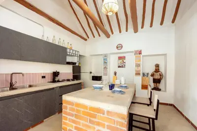 a kitchen with a table and chairs and a brick wall at Sweet Helen Casa Santa in Rionegro