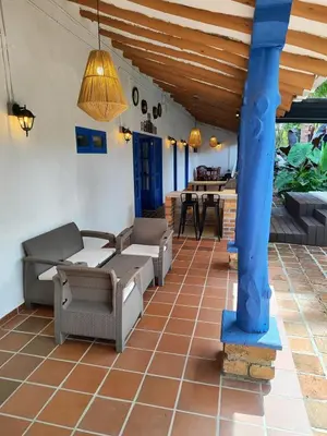 a patio with couches and tables and a blue pole at Sweet Helen Casa Santa in Rionegro