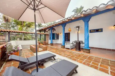 a patio with a table and an umbrella at Sweet Helen Casa Santa in Rionegro