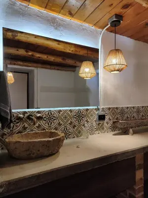 a bathroom with a sink and two lights and a mirror at Sweet Helen Casa Santa in Rionegro