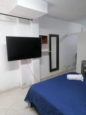 a bedroom with a flat screen tv on the wall at Apartaestudio en Medellín Barrio Buenos Aires in Medellín