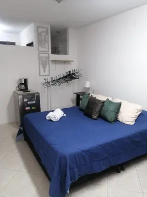 a bedroom with a bed with blue sheets and pillows at Apartaestudio en Medellín Barrio Buenos Aires in Medellín