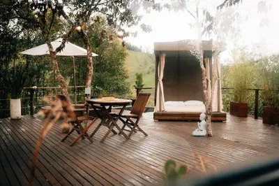 a deck with a table and chairs and a tent at Forest El Retiro, cabañas en el bosque in El Retiro