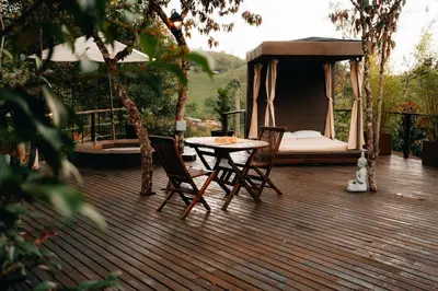 a wooden deck with a table and chairs and a tent at Forest El Retiro, cabañas en el bosque in El Retiro