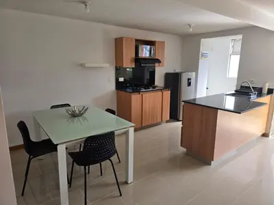 a kitchen with a table and chairs in a room at Amoblado Belen Avenida in Medellín