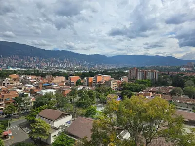 a city with buildings and mountains in the background at Amoblado Belen Avenida in Medellín