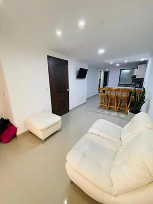 a living room with a white couch and a table at Acogedora casa en el carmen de Viboral in Carmen de Viboral