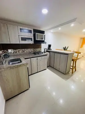 a kitchen with stainless steel appliances and a table at Acogedora casa en el carmen de Viboral in Carmen de Viboral