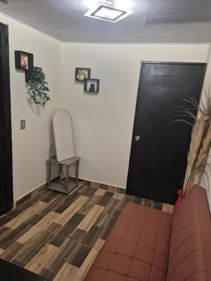 a living room with a black door and a chair at Medellín urban refuge in Medellín