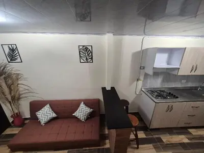 a living room with a couch and a kitchen at Medellín urban refuge in Medellín